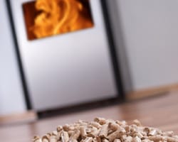 Pelletkachel met een oranje vlam en een voorraad pellets